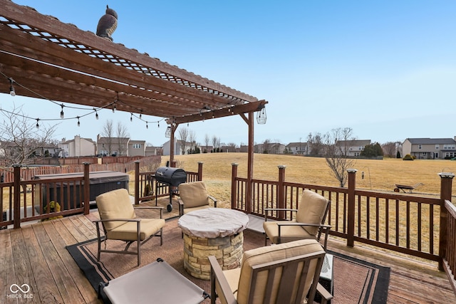 wooden deck featuring a fire pit, a yard, grilling area, and a pergola