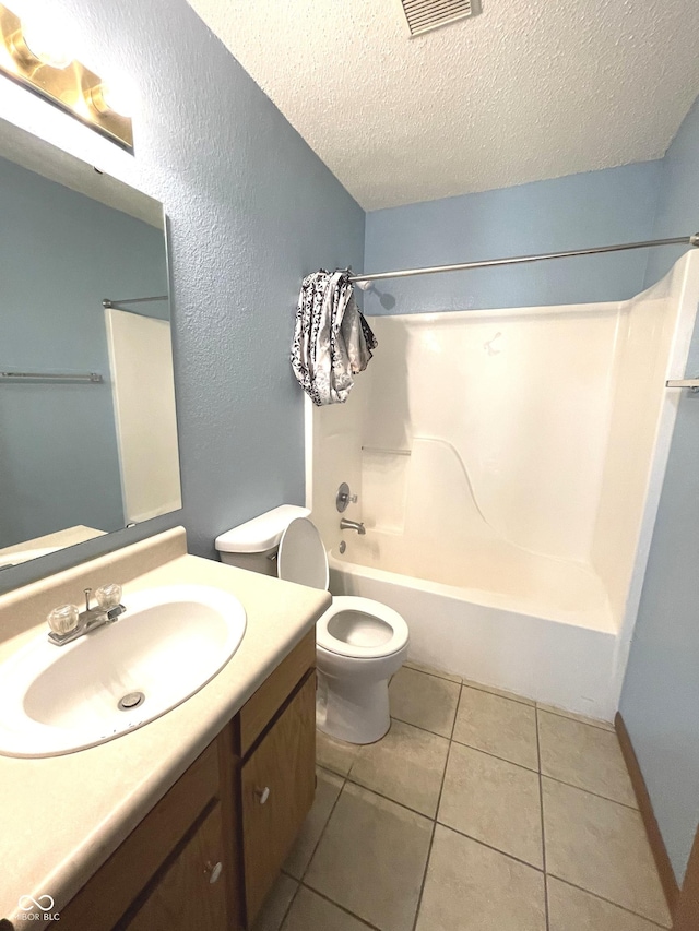 full bathroom featuring vanity, a textured ceiling, bathing tub / shower combination, tile patterned flooring, and toilet