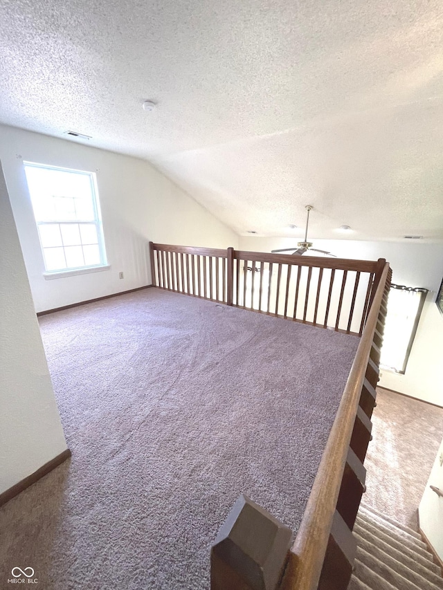 bonus room with a textured ceiling, carpet floors, ceiling fan, and lofted ceiling