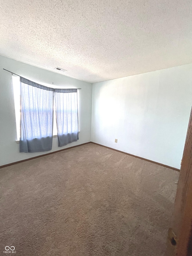 spare room featuring carpet floors and a textured ceiling