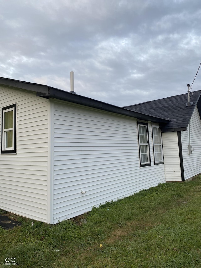 view of side of home with a yard