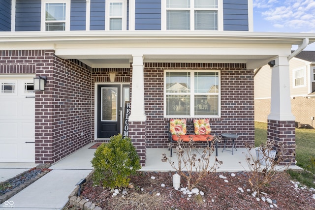 view of exterior entry featuring covered porch and a garage