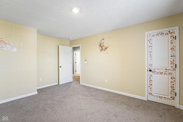 empty room featuring light carpet and a textured ceiling