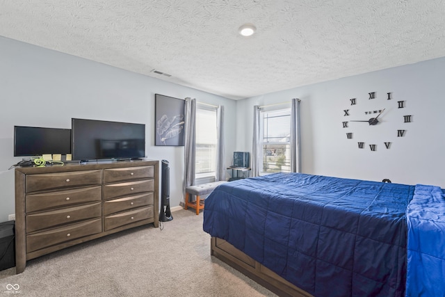 bedroom featuring a textured ceiling and light colored carpet