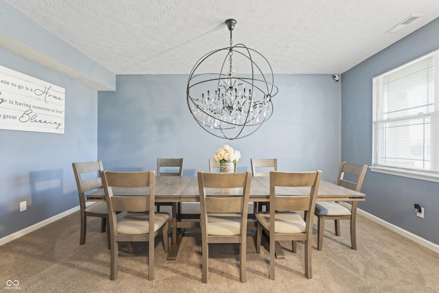 carpeted dining area featuring a chandelier and a textured ceiling