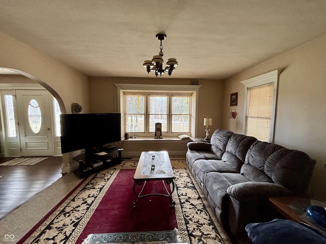 living room with arched walkways and a chandelier