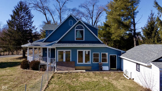 view of front of home featuring covered porch, a front lawn, and a shingled roof