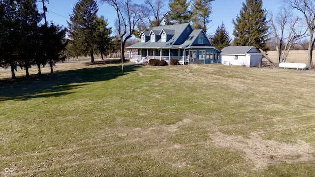 view of front of property featuring a front lawn, a porch, and an outbuilding