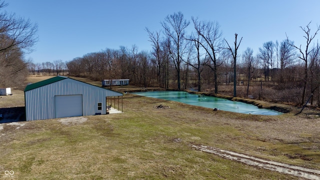 view of pool with a lawn and an outbuilding