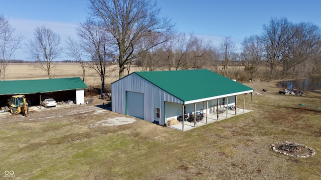 view of pole building with driveway and a yard