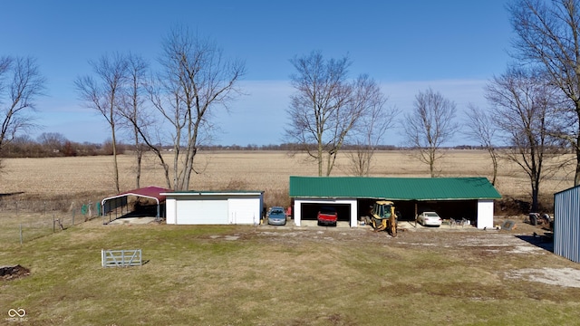 view of front facade featuring an outbuilding, a pole building, a rural view, and driveway