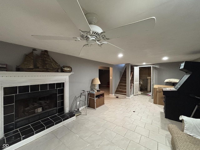 living room featuring ceiling fan, stairway, a fireplace, and baseboards