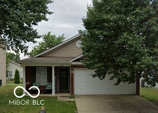 view of front of property featuring central AC, a garage, and a front lawn