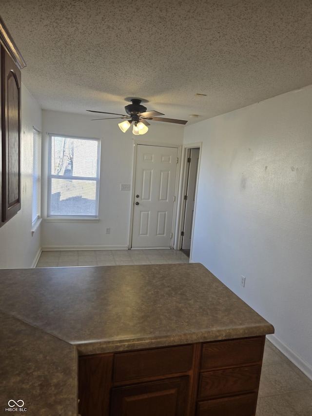 kitchen featuring dark brown cabinetry, a textured ceiling, and ceiling fan