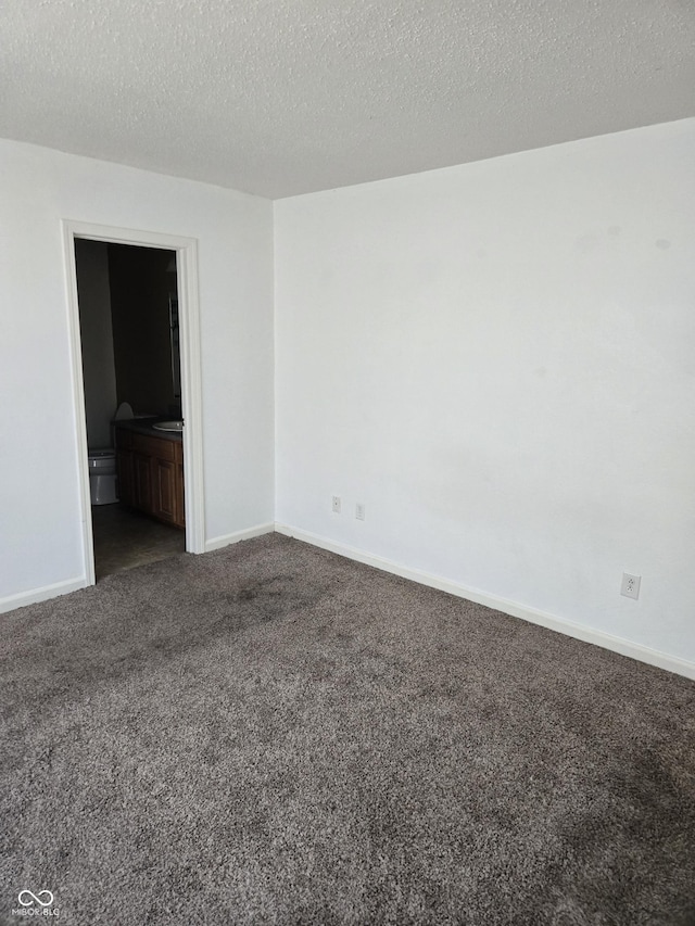 carpeted empty room featuring a textured ceiling