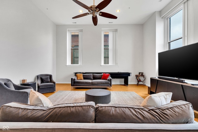 living room with ceiling fan and light hardwood / wood-style flooring