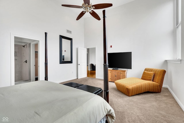 bedroom featuring ceiling fan, light carpet, and a high ceiling