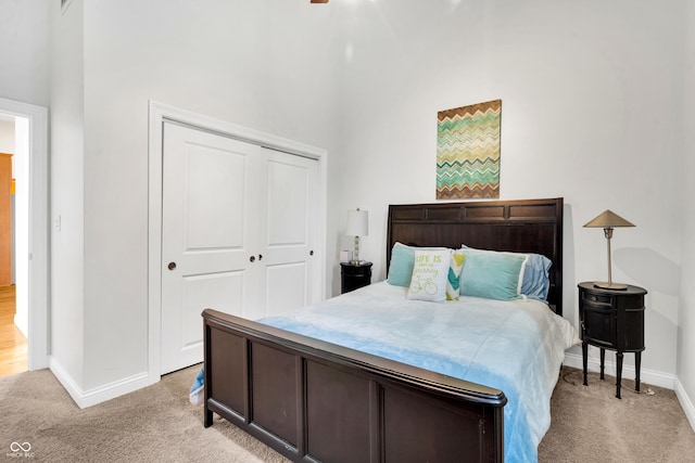 bedroom featuring a towering ceiling, light colored carpet, and a closet