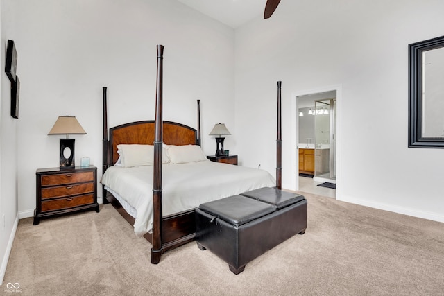 bedroom with ceiling fan, ensuite bathroom, and light carpet