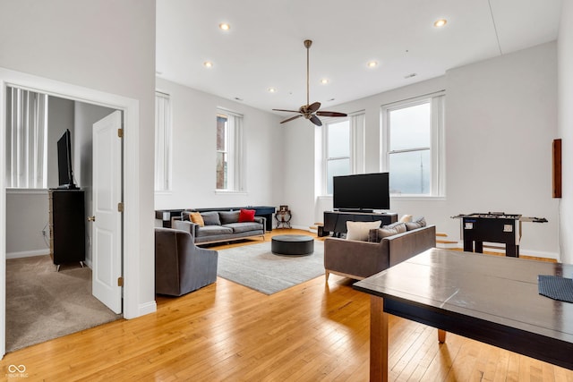 living room featuring light hardwood / wood-style flooring and ceiling fan