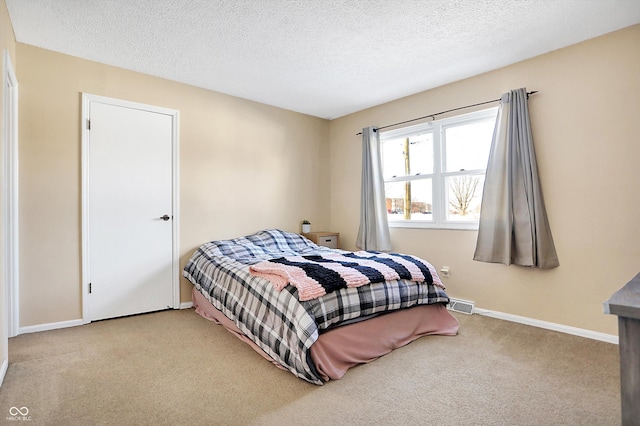 carpeted bedroom featuring a textured ceiling