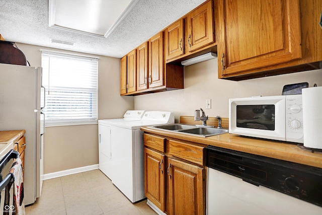 laundry area featuring sink, a textured ceiling, and independent washer and dryer