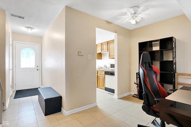 tiled office space with ceiling fan and a textured ceiling