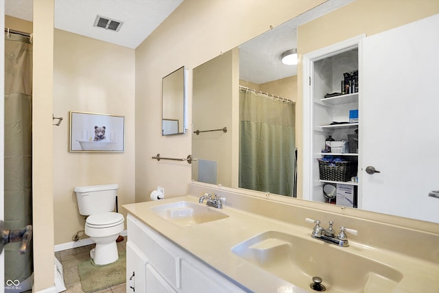 bathroom featuring tile patterned flooring, vanity, and toilet