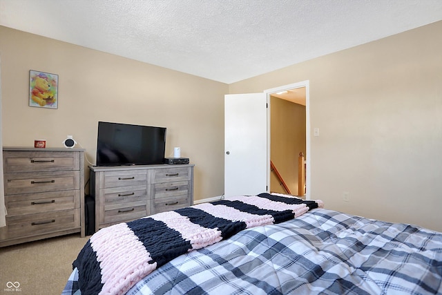 bedroom featuring light colored carpet and a textured ceiling