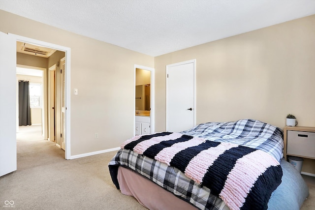 carpeted bedroom with connected bathroom and a textured ceiling