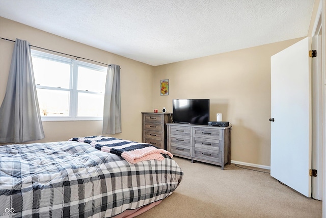 bedroom with light colored carpet and a textured ceiling