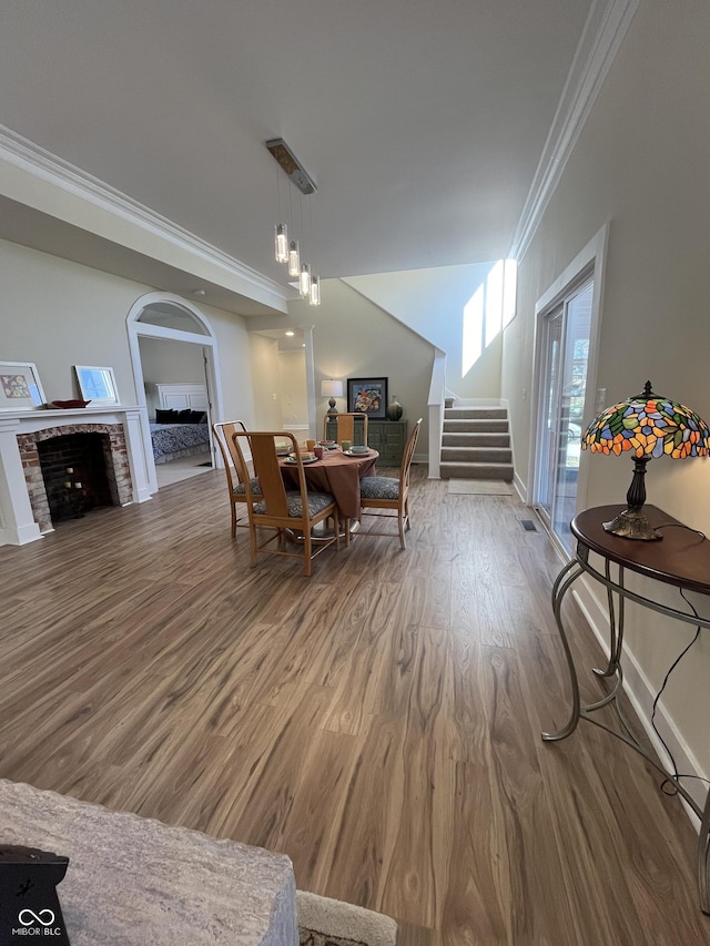 dining area featuring wood-type flooring and crown molding