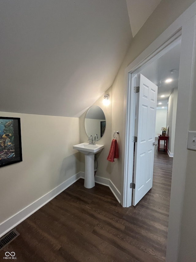 bathroom featuring hardwood / wood-style floors and vaulted ceiling