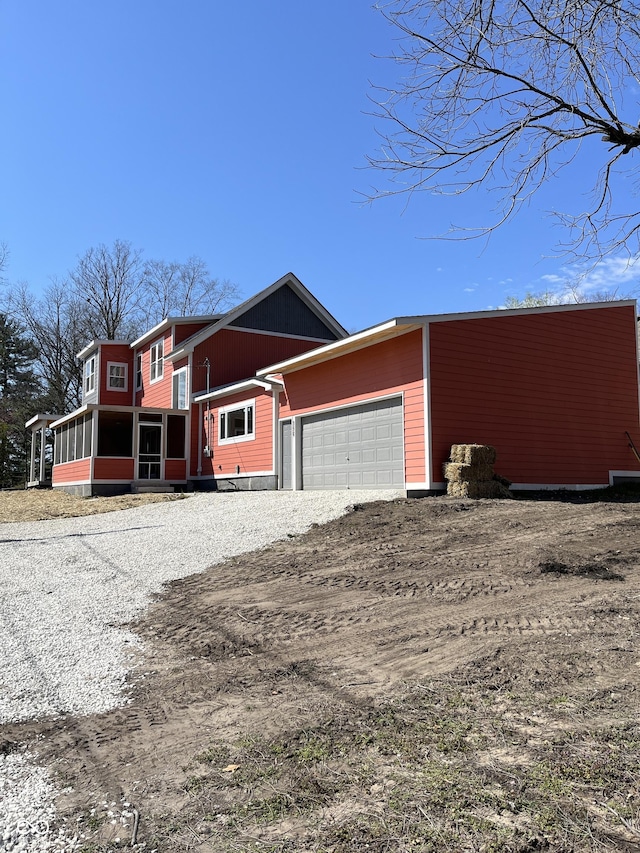 view of front of home with a garage and a sunroom