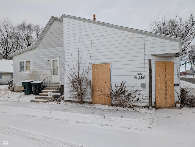 view of snow covered rear of property