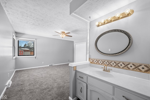 bathroom featuring ceiling fan, a textured ceiling, and vanity