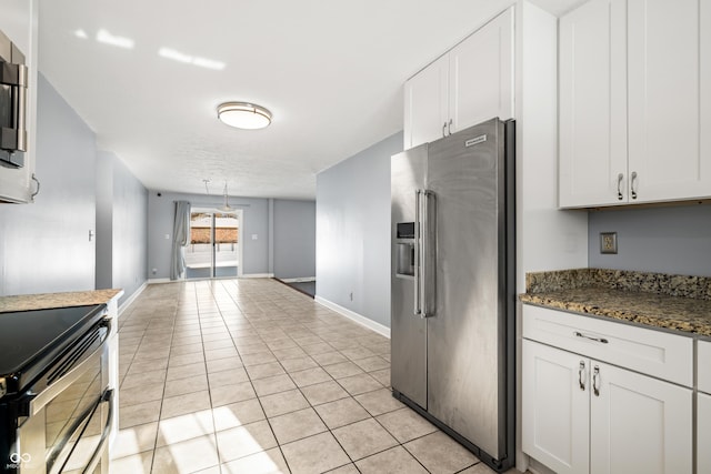 kitchen featuring white cabinetry, high end refrigerator, black electric range oven, dark stone countertops, and light tile patterned floors