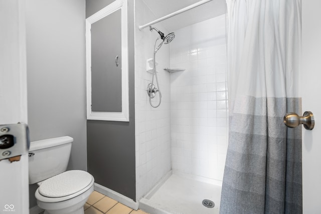 bathroom featuring tile patterned floors, toilet, and walk in shower