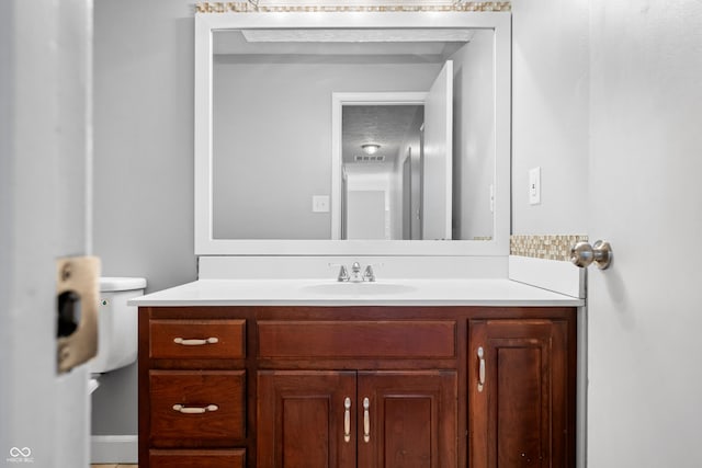 bathroom with vanity, a textured ceiling, and toilet