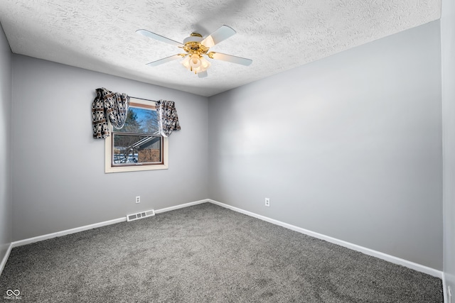 carpeted spare room with a textured ceiling and ceiling fan