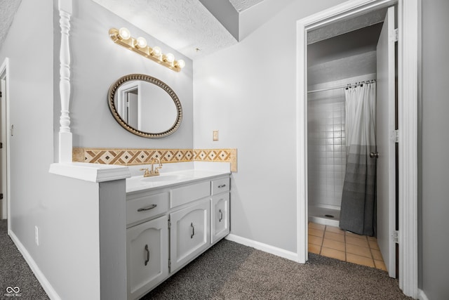 bathroom with vanity, a textured ceiling, tile patterned floors, and walk in shower