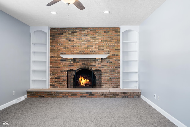 unfurnished living room featuring built in shelves, carpet floors, and a textured ceiling