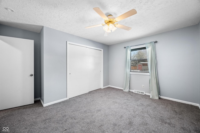 unfurnished bedroom with carpet flooring, a textured ceiling, a closet, and ceiling fan