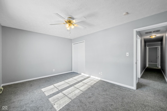 empty room featuring carpet flooring, ceiling fan, and a textured ceiling