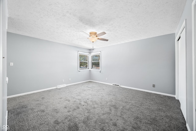 unfurnished room featuring ceiling fan, carpet floors, and a textured ceiling