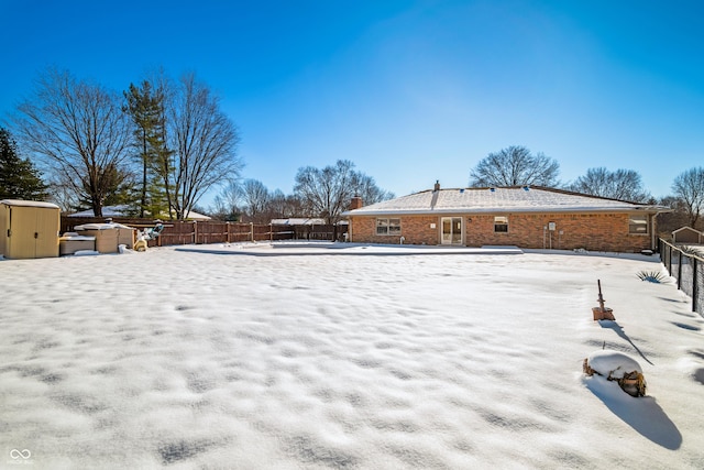 yard covered in snow with a storage unit