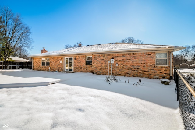 view of snow covered back of property