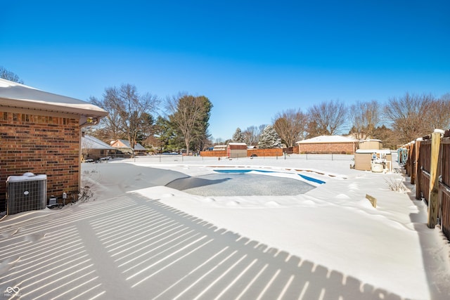 snow covered pool with central air condition unit