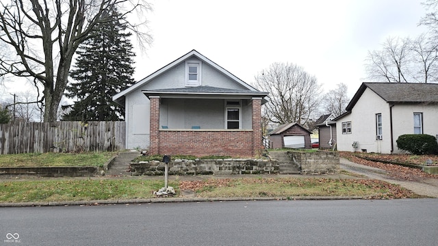 bungalow with a garage and an outbuilding