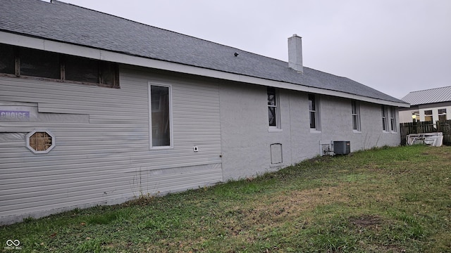 view of property exterior featuring a lawn and central air condition unit